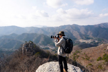 Photographer on top of a mountain and looking at the landscape.の素材