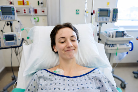 Portrait of a smiling female patient lying in bed at the hospitalの素材