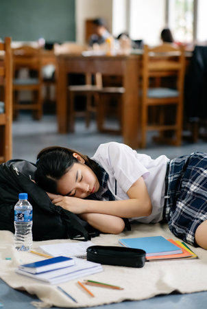 Portrait of Asian female student sleeping on the floor in the classroomの素材