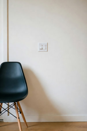 Interior of a room with black chair and electrical outlet on the wallの素材
