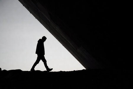 Silhouette of a man walking in the middle of a tunnelの素材