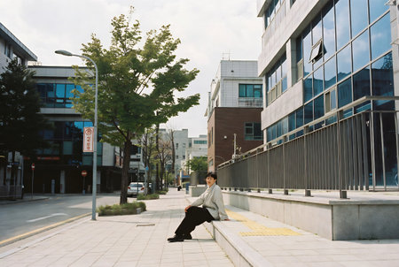 A man in a business suit is sitting on a bench in the city.の素材
