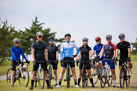 Group of friends cycling together in the park. Healthy lifestyle and sport concept.の素材