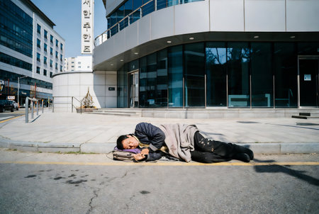 Homeless beggar sleeping on the street in Hong Kong.の素材
