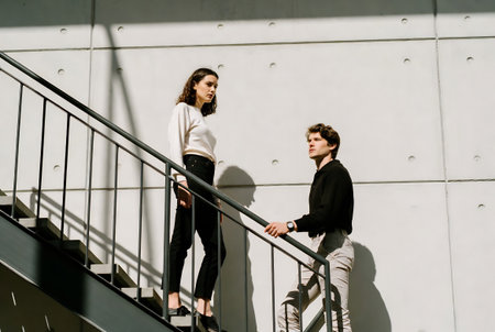Young couple in love walking down the stairs of a modern building.の素材