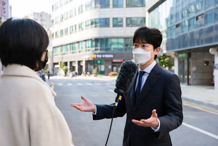 Businessman and businesswoman talking in the city with face mask.の素材