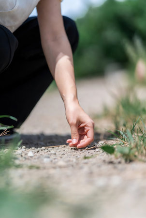 Closeup of a woman's hand walking on a path in the countrysideの素材