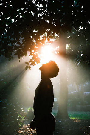 Silhouette of a woman standing in the forest with sunlight.の素材