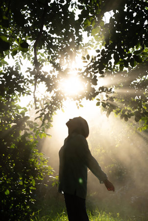 Man in the forest with sunbeams and lens flare effect.の素材