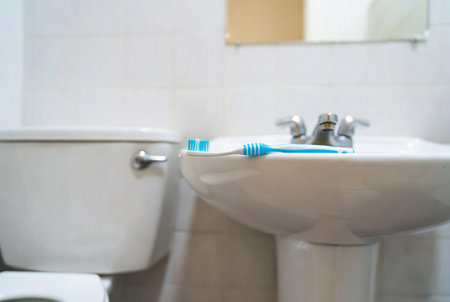 Toothbrush and toothpaste on toilet bowl in the bathroom.の素材