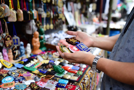 Unidentified man chooses souvenirs at a souvenir shop in Bangkok, Thailand.の素材