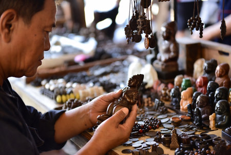 Unidentified Vietnamese man making souvenirs at the market.の素材
