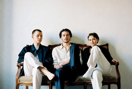 Three asian men sitting on a sofa and looking at the cameraの素材