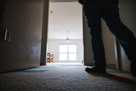 Man standing in an empty room with a window in the background.の素材