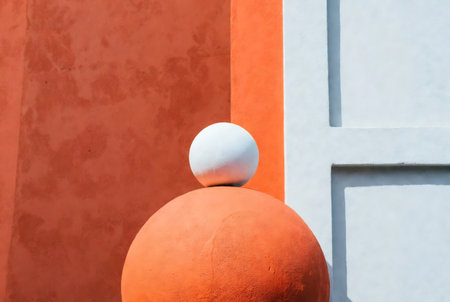 Orange and white wall with a sphere in the shape of a ballの素材