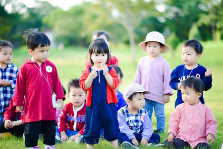 Group of asian kids playing together in the park, education conceptの素材