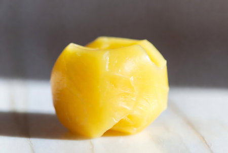 Close-up of a yellow egg yolk on a wooden tableの素材