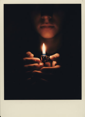 Man holding a lighter in his hand. Photo in old color image style.の素材