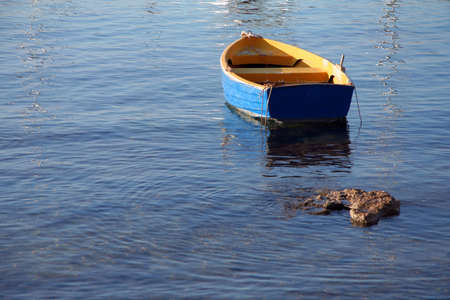 An empty colorful boat on calm seaの写真素材