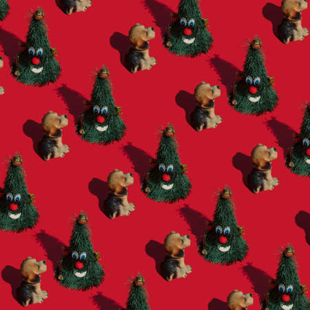 Creative pattern with a pet and Christmas tree. Minimal concept with a dog. Pastel red background.の写真素材