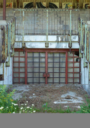 The doors of the abandoned stadium were rusty. With the stands in the background.の写真素材