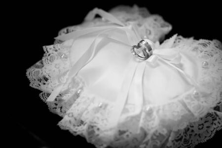 Wedding rings on a white  heart-shaped cushion.の写真素材