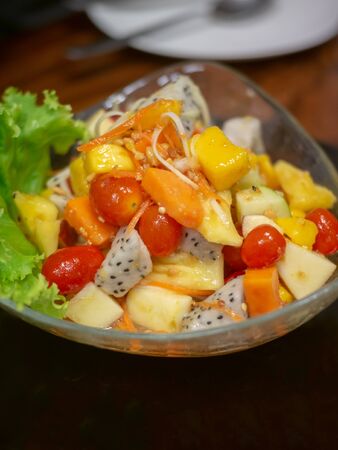 Healthy fresh fruit salad dishes are in a bowl on the table.の写真素材