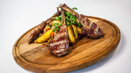 Chopped lamb ribs with potatoes peppers and rocketの写真素材