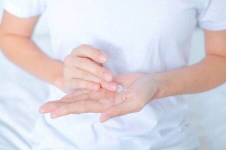 Woman applying moisturizing cream/lotion on hands, beauty concept.