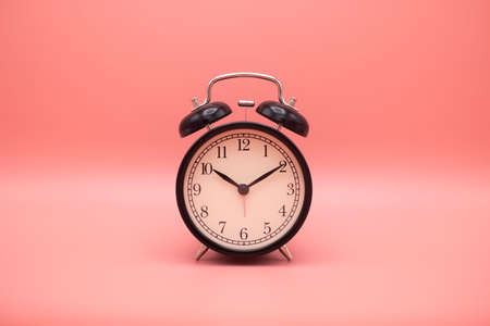 Alarm clock on pink background with copy space for you design.