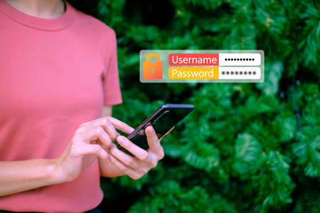 Woman holding smartphone with username and password icon on christmas tree background, Technology concept.の写真素材