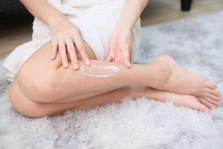 Woman applying natural cream, Woman moisturizing her leg with cosmetic cream with copy space.の写真素材