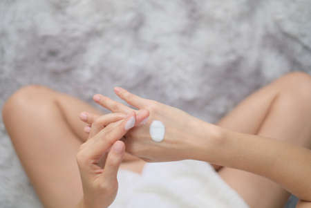 Woman applying natural cream, Woman moisturizing her hand with cosmetic cream, Spa and Manicure concept, Top view.の写真素材
