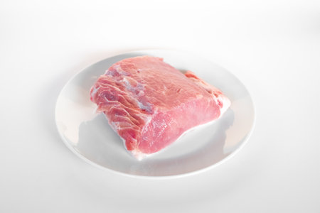 sliced raw pork meat isolated on white background ready for cooking. a piece of porkの写真素材