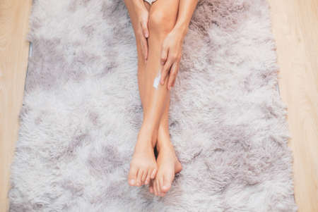 Woman applying natural cream, Woman moisturizing her leg with cosmetic cream with copy space.の写真素材