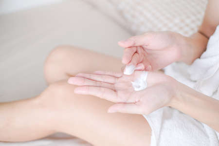 Woman applying natural cream on bed, Woman moisturizing her hand with cosmetic cream, Spa and Manicure concept.の写真素材