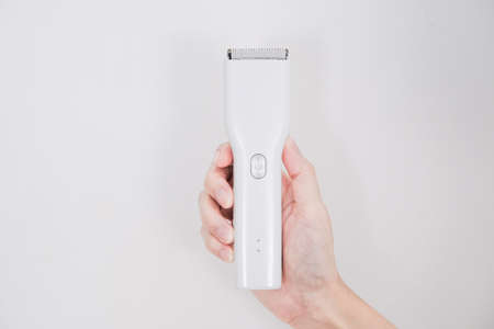 Hand holding clipper on white background.