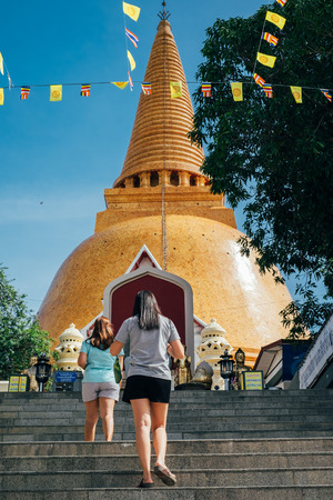 thai pagoda with two women walking upstairのeditorial素材