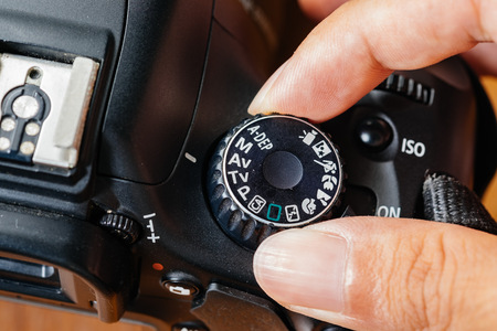 Av dial mode on dslr camera with fingers on the dialの写真素材