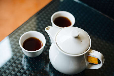 Teapot with cups of tea