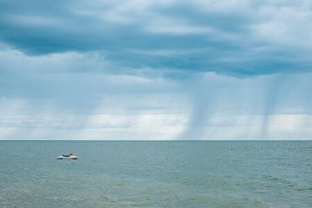 Raining cloud seascape with jetskiの写真素材