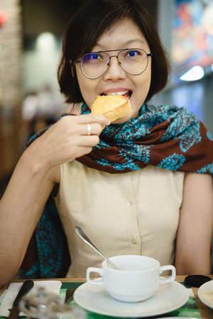 Asian women eating toast bread.の写真素材