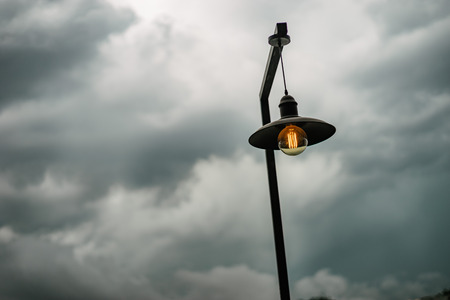 Lamp post under stormy sky.