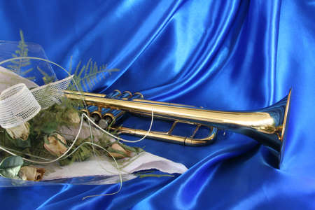 Gold lacquer trumpet and old sere roses on blue satin の写真素材