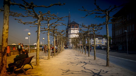 DUSSELDORF, GERMANY - circa 2016: Local people enjoy the good weather and seat on the steps of the promenade by the Rhine in Dusseldorf on a clear Spring dayのeditorial素材