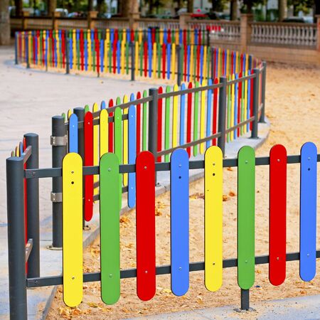 Colourful rows of painted wood on a playground fence の写真素材