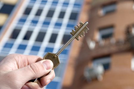 On a background of a modern brick house, hand with keys from an apartment.の写真素材