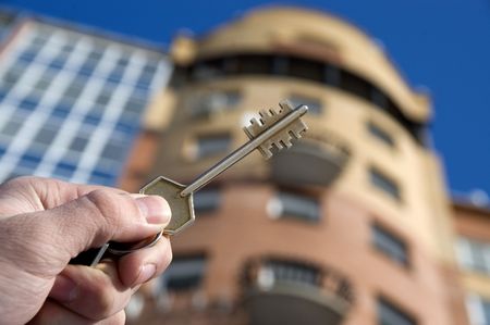 On a background of a modern brick house, hand with keys from an apartment.の写真素材