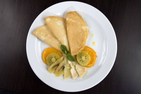 Pancakes with fruit on a white plate.の写真素材