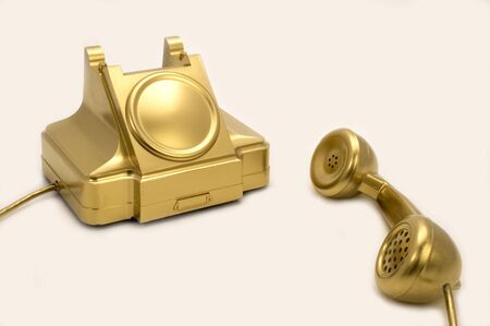 The telephone of gold colour on a white background.の写真素材
